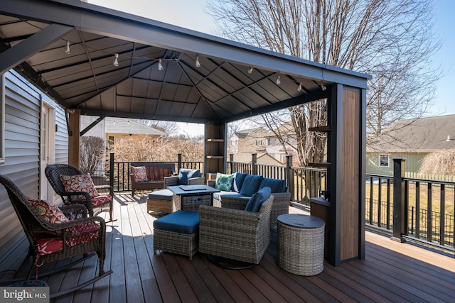 wooden terrace with a gazebo and an outdoor living space with a fire pit