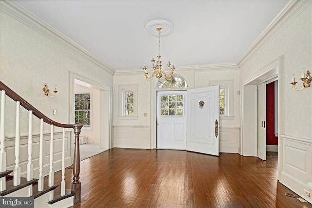 entryway featuring stairway, dark wood-type flooring, a healthy amount of sunlight, and a decorative wall