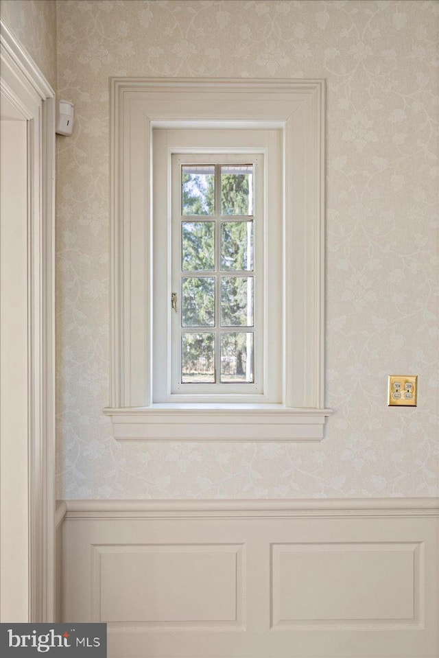 room details featuring wainscoting and wallpapered walls