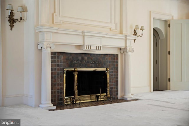 interior details with a tiled fireplace, baseboards, and ornate columns