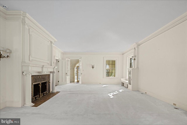 unfurnished living room featuring carpet floors, a large fireplace, baseboards, and ornamental molding