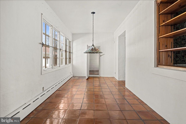 unfurnished dining area featuring dark tile patterned floors, built in features, and a baseboard radiator