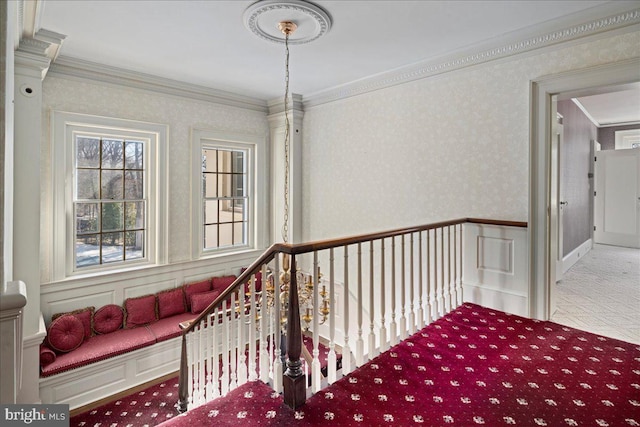 interior space with a wainscoted wall, an upstairs landing, wallpapered walls, carpet flooring, and crown molding