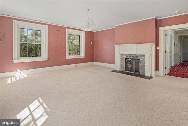 unfurnished living room with carpet, baseboards, a fireplace with flush hearth, ornamental molding, and a notable chandelier