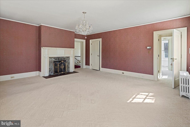 unfurnished living room with a fireplace, crown molding, and an inviting chandelier