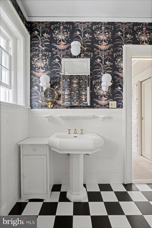 bathroom with wallpapered walls, tile patterned floors, tile walls, and a wainscoted wall