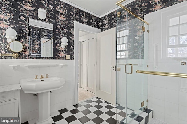 full bathroom featuring tile patterned floors, a stall shower, wainscoting, and wallpapered walls