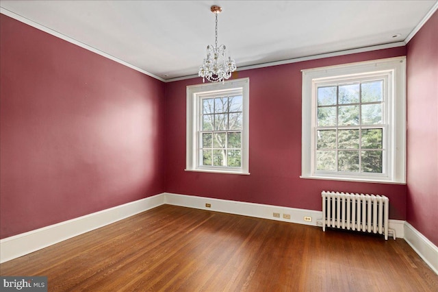 unfurnished room with baseboards, radiator heating unit, ornamental molding, an inviting chandelier, and wood finished floors