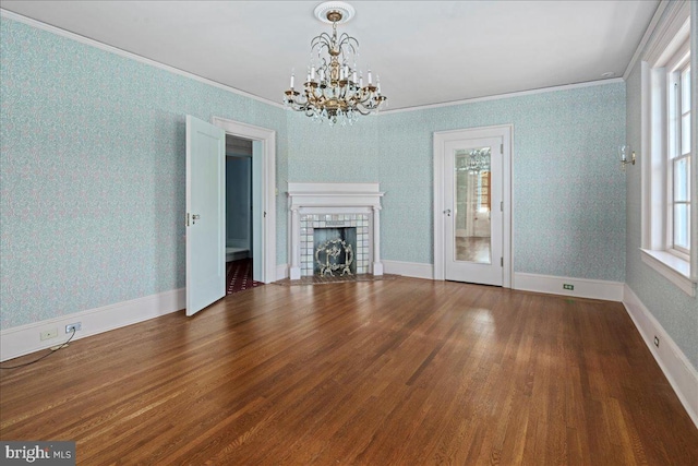 unfurnished living room featuring wood finished floors, baseboards, wallpapered walls, a tile fireplace, and crown molding