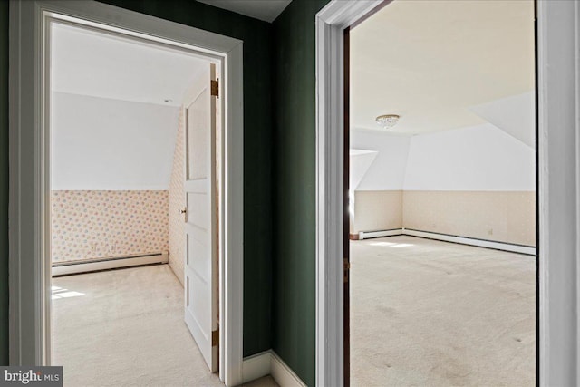 hallway featuring lofted ceiling, carpet, and baseboard heating