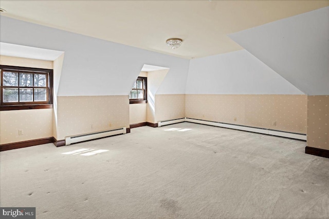 empty room featuring a wealth of natural light, a baseboard heating unit, carpet, and wallpapered walls