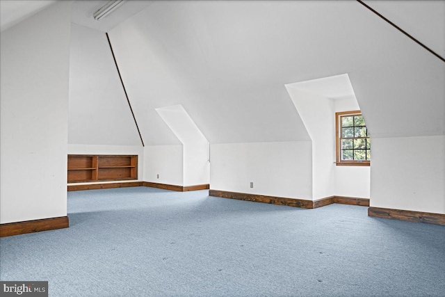 bonus room with baseboards, lofted ceiling, and carpet