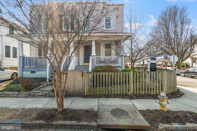 multi unit property with a fenced front yard, a porch, and a gate