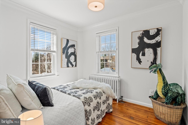 bedroom featuring hardwood / wood-style floors, ornamental molding, and radiator heating unit