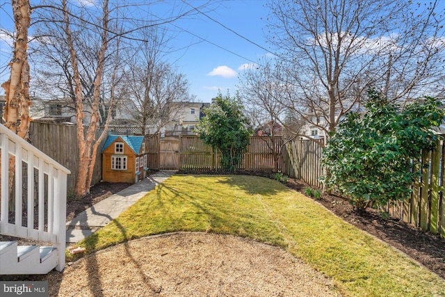 view of yard with a fenced backyard and a gate