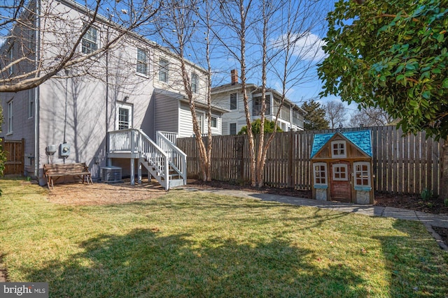 view of yard featuring an outdoor structure, central air condition unit, and a fenced backyard