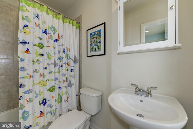 bathroom with shower / bathtub combination with curtain, toilet, and a sink