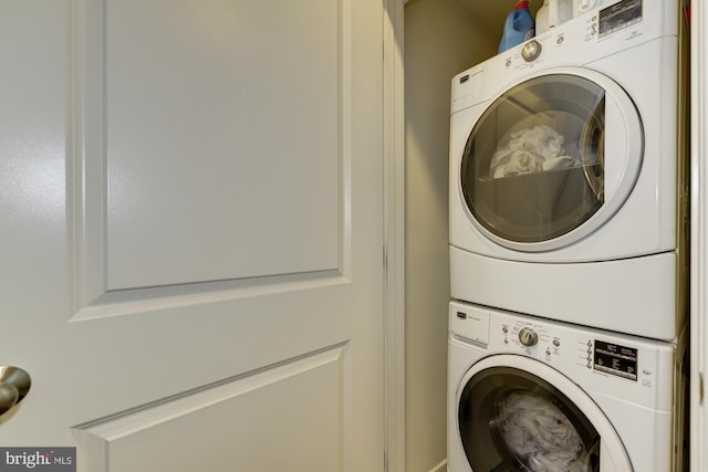 clothes washing area featuring laundry area and stacked washing maching and dryer