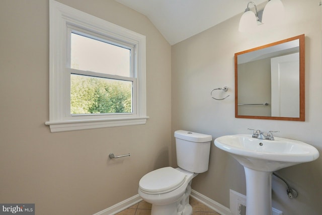 half bath featuring baseboards, lofted ceiling, toilet, and tile patterned flooring