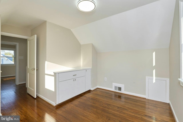 bonus room with visible vents, lofted ceiling, baseboards, and dark wood finished floors