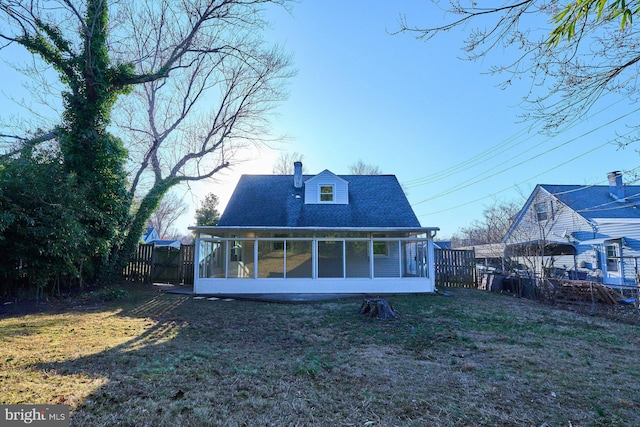 back of property with fence, roof with shingles, a chimney, a yard, and a sunroom