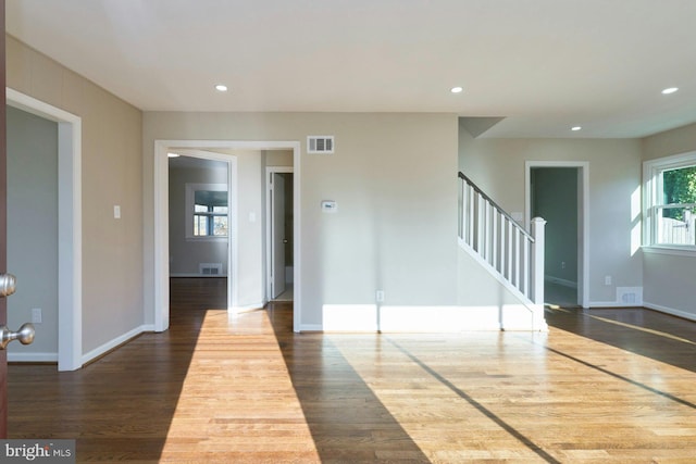 empty room featuring visible vents, recessed lighting, stairway, and dark wood-type flooring