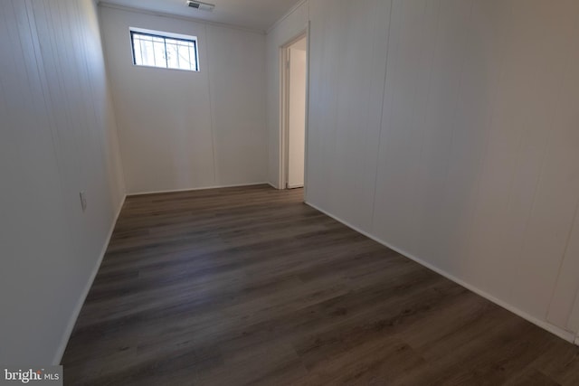 empty room featuring visible vents and dark wood-style floors