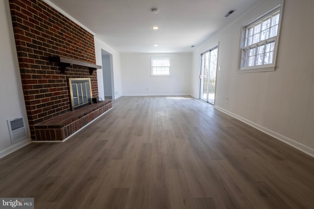 unfurnished living room featuring wood finished floors, a fireplace, visible vents, and baseboards