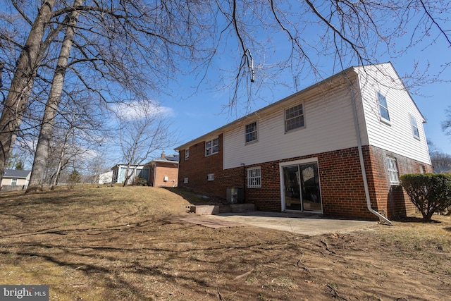 back of house with a patio area and brick siding