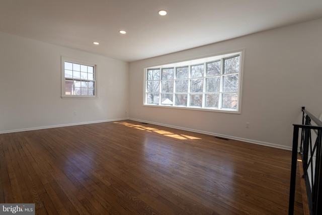 spare room with recessed lighting, visible vents, baseboards, and dark wood-type flooring