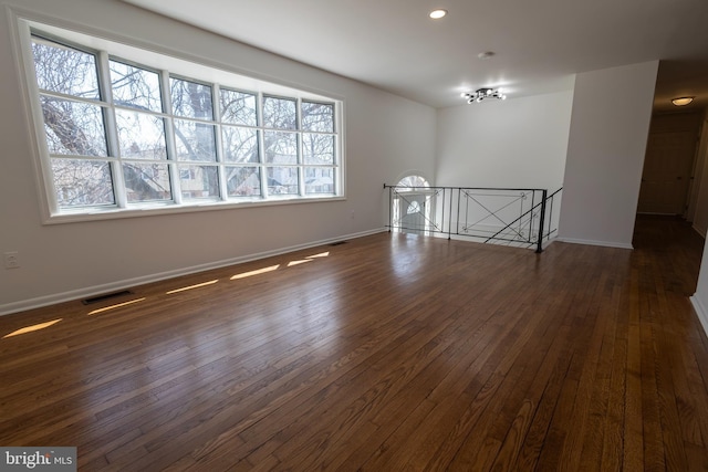 empty room featuring recessed lighting, visible vents, baseboards, and dark wood-type flooring