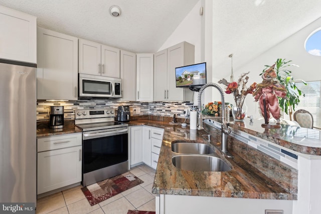 kitchen with tasteful backsplash, light tile patterned flooring, stainless steel appliances, and a sink