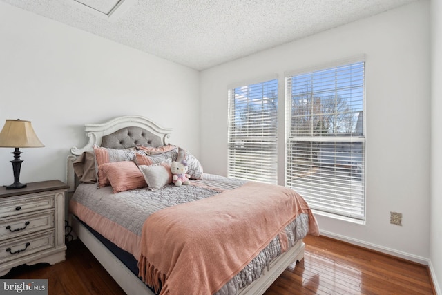 bedroom featuring hardwood / wood-style flooring, baseboards, and a textured ceiling