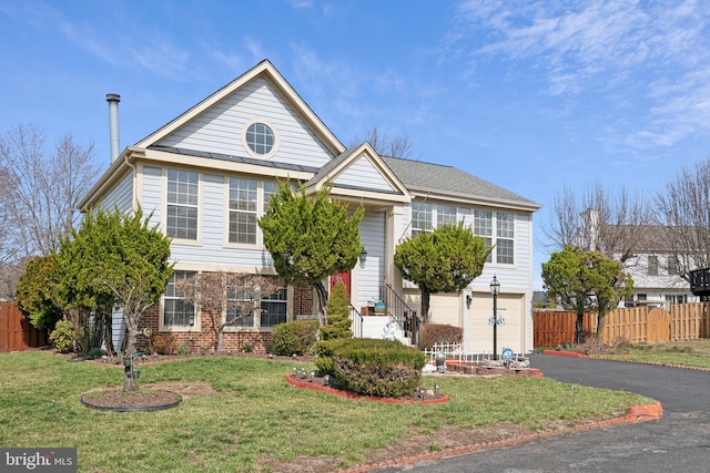 view of front of property with brick siding, a front lawn, fence, aphalt driveway, and a garage