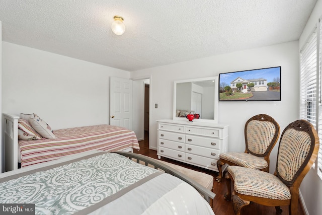 bedroom featuring wood finished floors and a textured ceiling