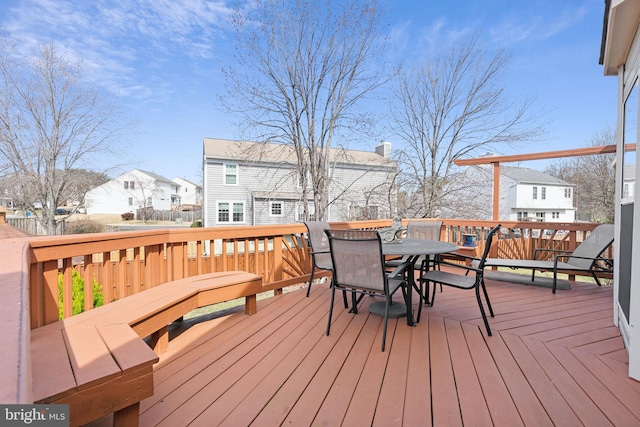 wooden deck featuring outdoor dining area and a residential view