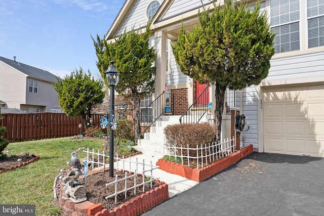 view of front facade featuring brick siding, a front yard, fence, and a garage