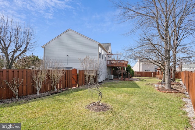 exterior space with central air condition unit, a deck, a lawn, and a fenced backyard