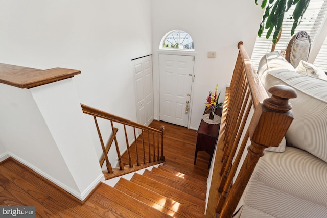 entryway with stairway, wood finished floors, and baseboards