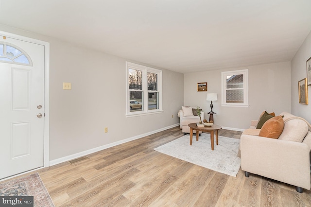 living area featuring visible vents, baseboards, and light wood-style flooring