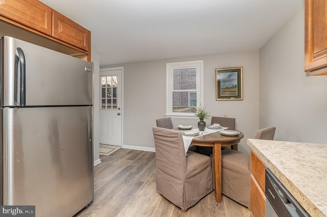 dining area featuring a wealth of natural light, light wood-type flooring, and baseboards