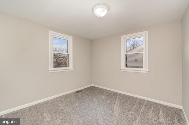 carpeted empty room with visible vents and baseboards