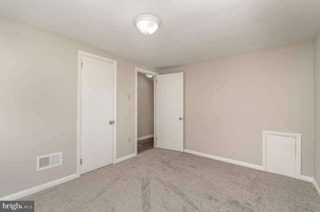 unfurnished bedroom featuring carpet flooring, baseboards, and visible vents