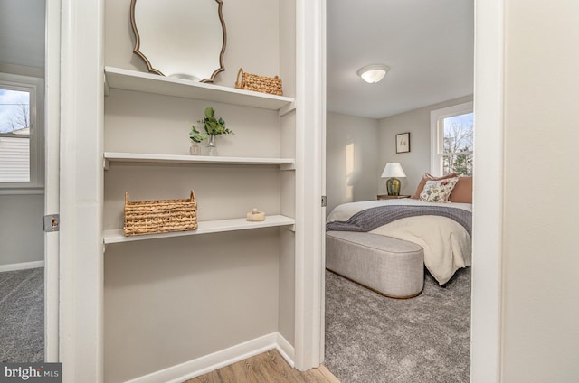 bedroom featuring baseboards, carpet floors, and wood finished floors