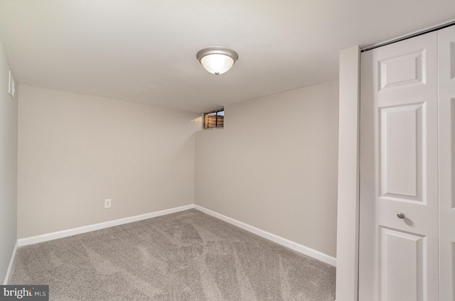 carpeted spare room featuring baseboards