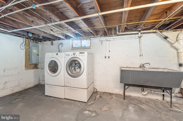 unfinished below grade area featuring electric panel, independent washer and dryer, and a sink