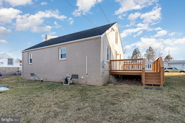 back of property with a deck, a yard, brick siding, and a chimney