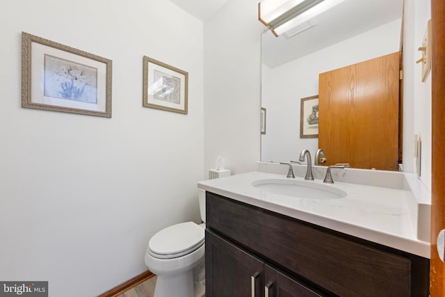 half bathroom with visible vents, toilet, and vanity