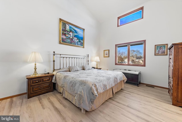 bedroom featuring light wood-type flooring, multiple windows, and baseboards