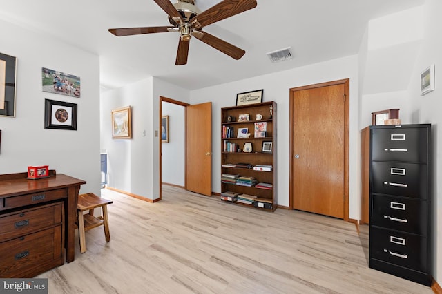 office featuring ceiling fan, visible vents, light wood-type flooring, and baseboards